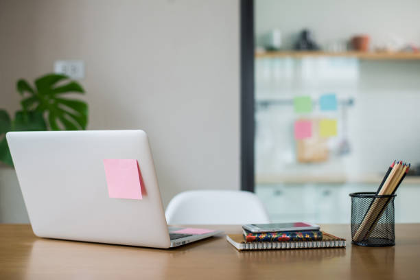 istock Working desk with laptop computer, document, paperwork, book, post-it and pencil. It is arranged neatly and decorated with plants to make it fresh. 1383274276