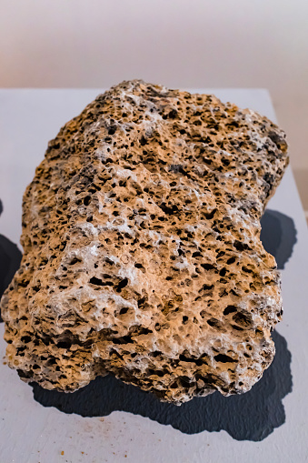 Isolated porous brown volcanic rock. Lava, pumice or volcanic pumice with unique pores, close-up