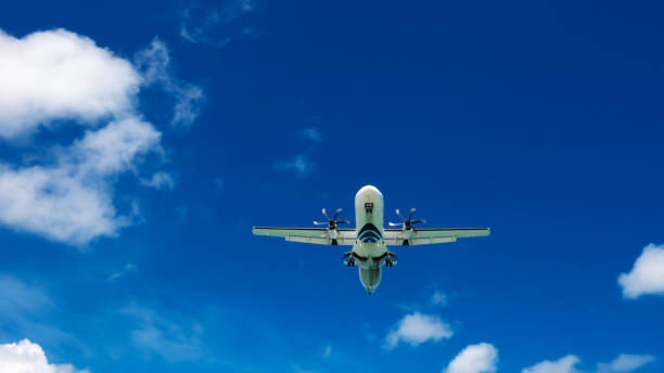 istock Airplane flying in a blue sky with clouds. 1383295671