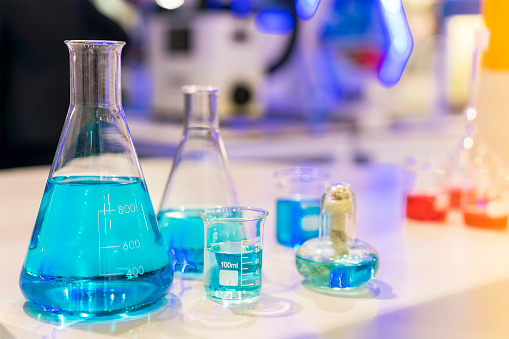 Close up of beautiful blue colorful chemistry liquid in various laboratory flask for science on table
