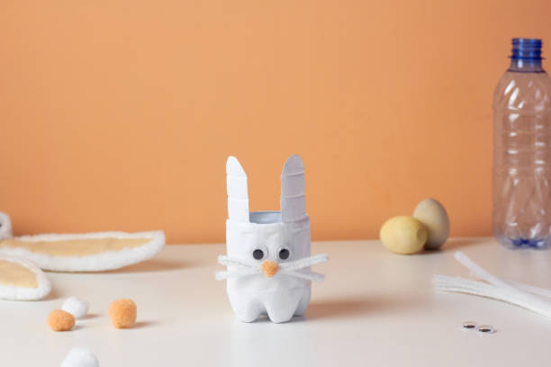 istock Easter bunny craft from plastic bottle. Kids DIY home activities. Handmade cute toy rabbit on table. Reuse concept 1383309967