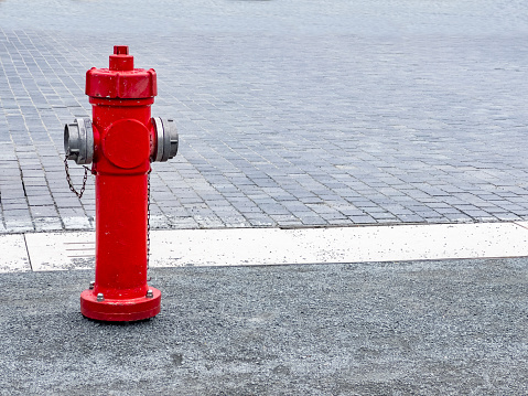 Single object spout fire. Water supply for fire extinguishers. A nice looking bright red fire hydrant from Dog's Eye View on a sidewalk. Brick shape ground with large blank space for additional text message