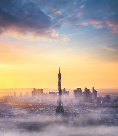 Paris skyline with fog around Eiffel tower at sunset. View from above.