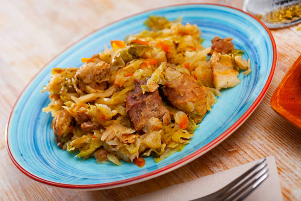 istock Appetizing cabbage stewed with pork meat on white plate 1383383592