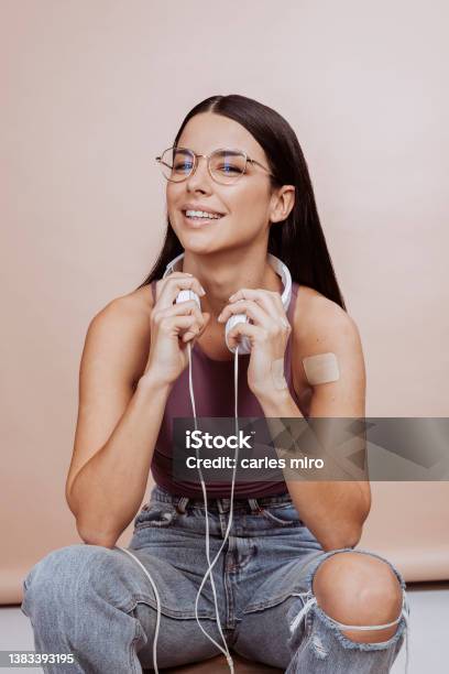 Young Cheerful Modern Woman With Headsets Sits On Stool At Studio Stock Photo - Download Image Now