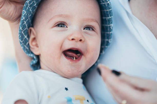 portrait of an adorable toothless baby boy smiling with his mouth full of food - healthy eating profile tropical fruit fruit imagens e fotografias de stock