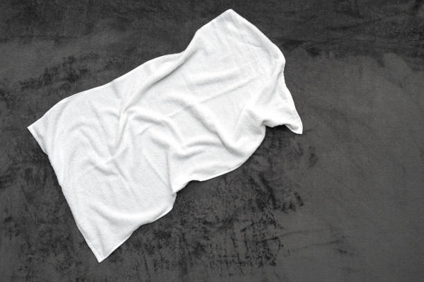 Used white towel on a bed at hotel room