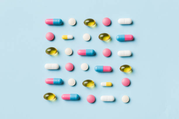 Many different pills and space for text on colorful background, top view. Different pills on color background, flat lay stock photo