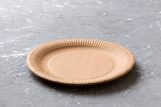perspective view of eco paper plate on cement background. empty space for your design - brown paper imagens e fotografias de stock