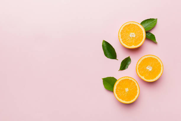 istock fresh Fruit orange slices on colored background. Top view. Copy Space. creative summer concept. Half of citrus in minimal flat lay with copy space 1383404272