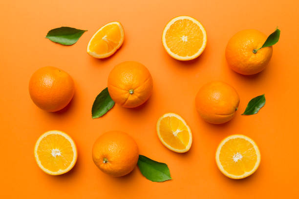 istock Fruit pattern of fresh orange slices on colored background. Top view. Copy Space. creative summer concept. Half of citrus in minimal flat lay 1383404275