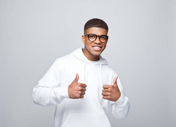 istock Cheerful young man standing with thumbs up 1383406037