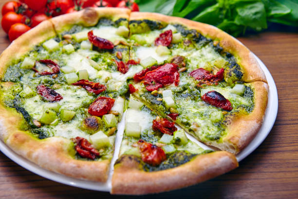 istock Pre-cut pizza with basil sauce, dried cherry tomatoes, mozzarella  and parmesan 1383411642