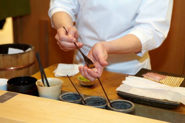 istock Hands of a Japanese chef preparing sushi 1383411654