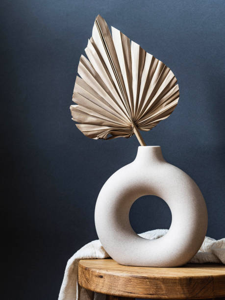 istock Round stylish ceramic vase with dried palm leaf. 1383411789