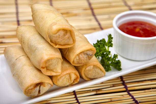 istock Spring rolls and its bowl of spicy vinegar sauce. 1383412082