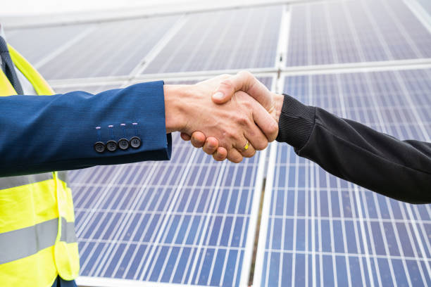 istock workers in  helmets two men shake hands after working on the installation of panels. 1383413505