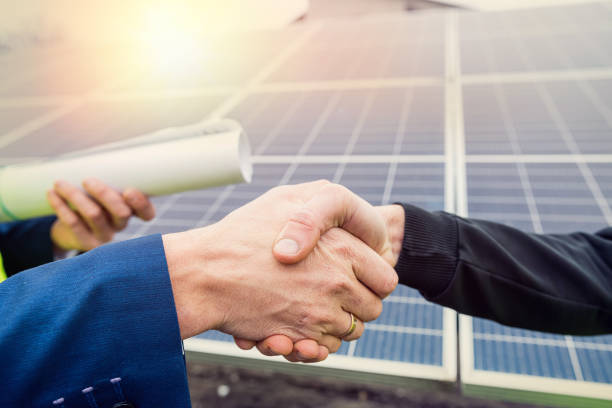 istock workers in  helmets two men shake hands after working on the installation of panels. 1383413994