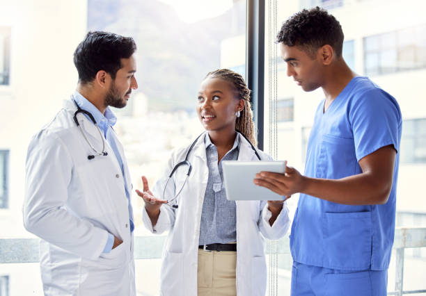 scatto di un gruppo di medici che utilizzano un tablet digitale al lavoro - healthcare worker foto e immagini stock