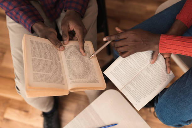 istock Unrecognizable man and woman reading and analyzing the book together 1383416961