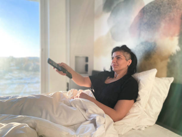 istock Women watching tv on the bed 1383417059