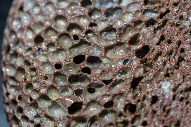 istock dark pumice stone with visible irregularities in a circular shape. 1383418486
