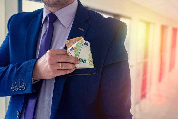 istock Businessman putting euro bills into pocket hit jacket 1383419276