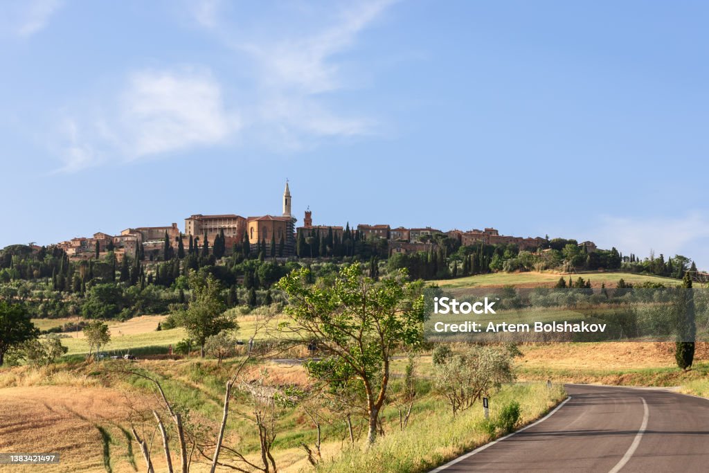 Road winding between the green hills of Tuscany and leading to the medieval town of Pienza Ancient Stock Photo