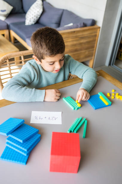 istock Little boy using the base 10 method to do addition at home 1383427222