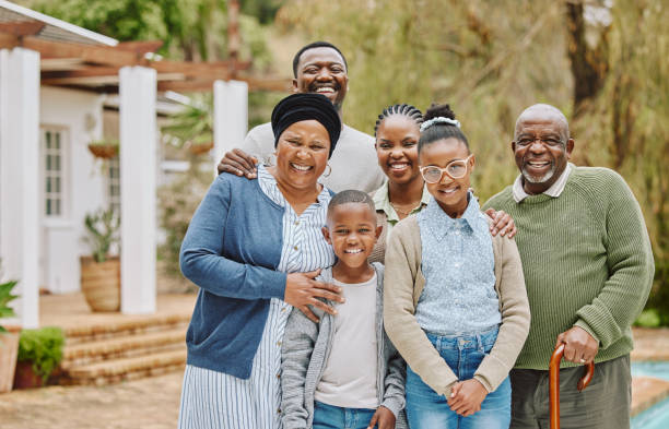 beschnittenes porträt einer mehrgenerationenfamilie, die draußen im garten steht - grandparent multi generation family grandfather child stock-fotos und bilder