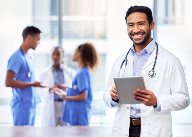 Shot of a young male doctor using a digital tablet at work Helping people back to good health doctor stock pictures, royalty-free photos & images