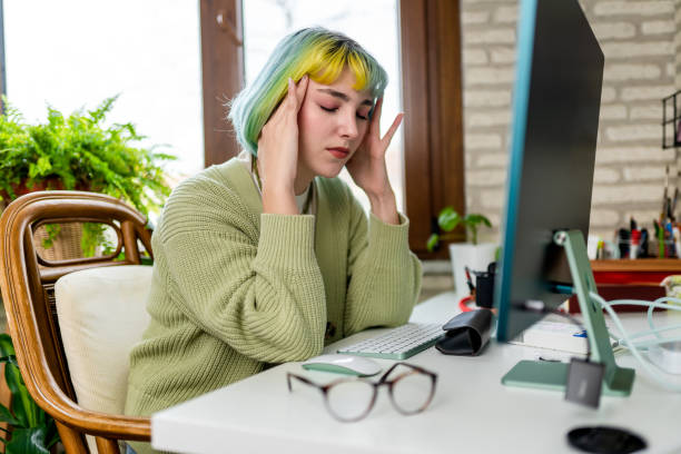 istock Young woman suffering from headache from too much computer use and work 1383446942