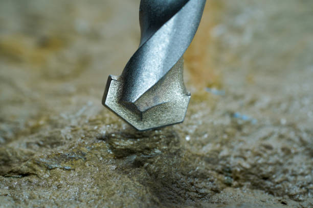 steinbohrer mit bohrpunkt in naturstein und beton im studio fotografiert - drill bit fotos stock-fotos und bilder