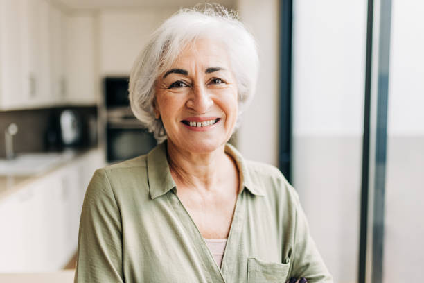 istock Senior woman smiling at the camera inside her home 1383447476