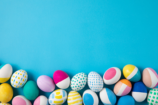 Colorful Easter eggs with spring flower leaf isolated over white background. Colored Egg Holiday border.