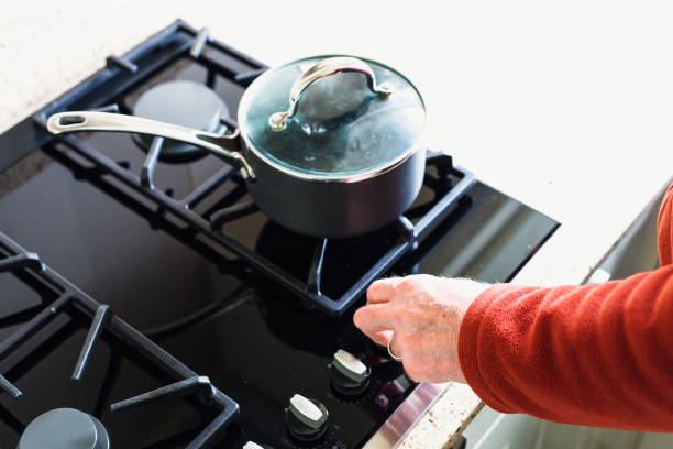 istock Hand adjusting gas hob dial - reducing energy consumption 1383457443