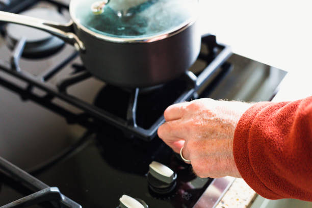 istock Hand adjusting gas hob dial - reducing energy consumption 1383457459