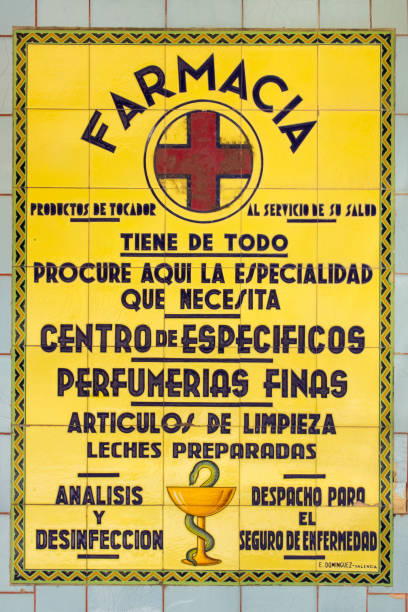 A Guarda, Pontevedra province, Spain- June 30, 2021:Close-up of ancient pharmacy sign and symbol in the street, old tiles. Wide products offer, text in spanish language. Galicia, Spain.