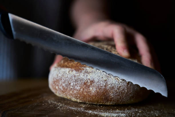 istock cutting wholegrain bread with bread slicer 1383462416