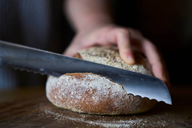 istock cutting wholegrain bread with bread slicer 1383462934