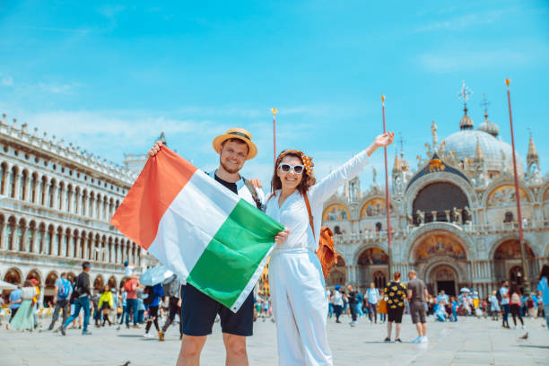 smiling couple holding italian flag venice central square san marco smiling couple holding italian flag venice central square san marco copy space stockholm town square sergels torg sweden stock pictures, royalty-free photos & images