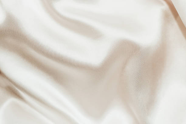 istock Nude shiny silk satin background with waves 1383465222
