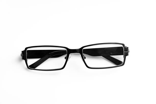 Black reading glasses with a contemporary frame are positioned on a smooth surface, highlighting their clear lenses and sleek style. Ideal for reading or screen use, these glasses enhance vision while providing comfort and functionality.