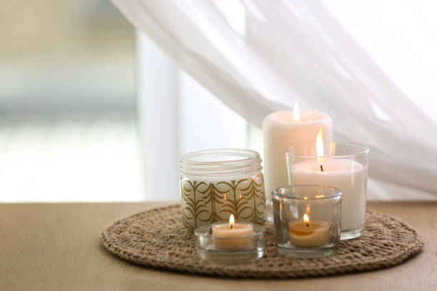 istock Beautiful burning candles on table at home 1383470639
