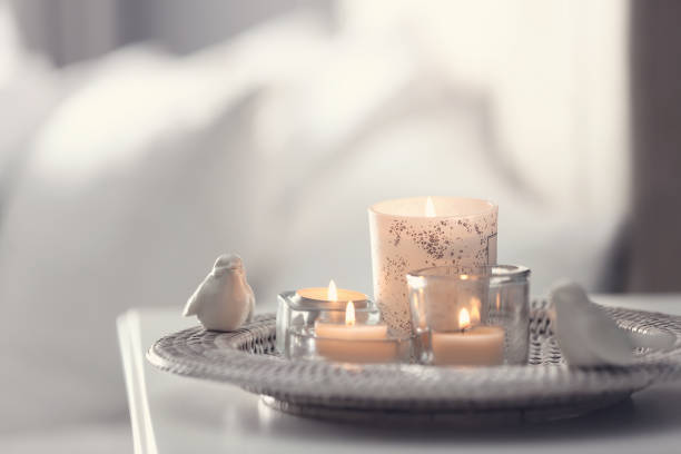Beautiful burning candles on tray against light background