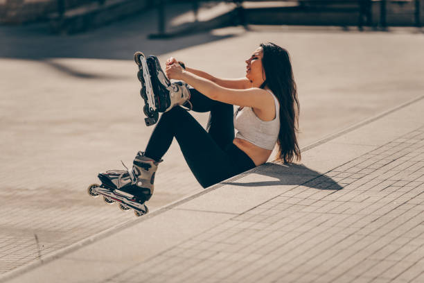 istock Girl sitting on wall and puts on skates 1383471697