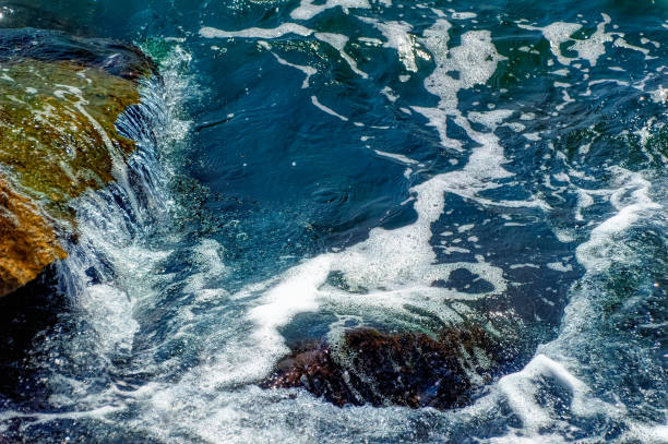 istock Foamy Mediterranean sea hitting rocky shore. 1383472203