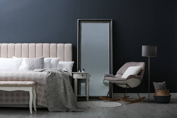 istock Elegant mirror near bed in stylish room interior 1383472314