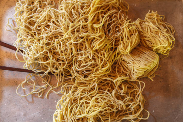 istock Yellow noodles in a tray on the kitchen table 1383472358