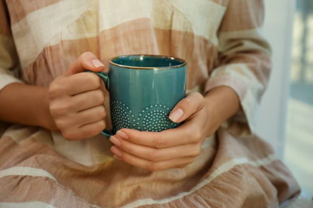 istock Woman holding elegant cup indoors, closeup view 1383472441